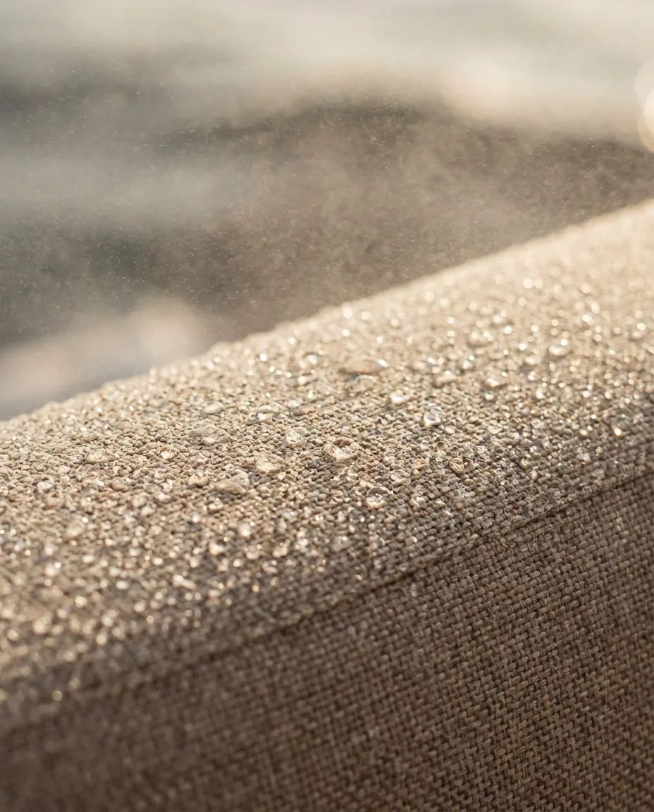 Macro-opname van maritieme waterafstotende outdoor stof met afparelende water- en zoutdruppels
