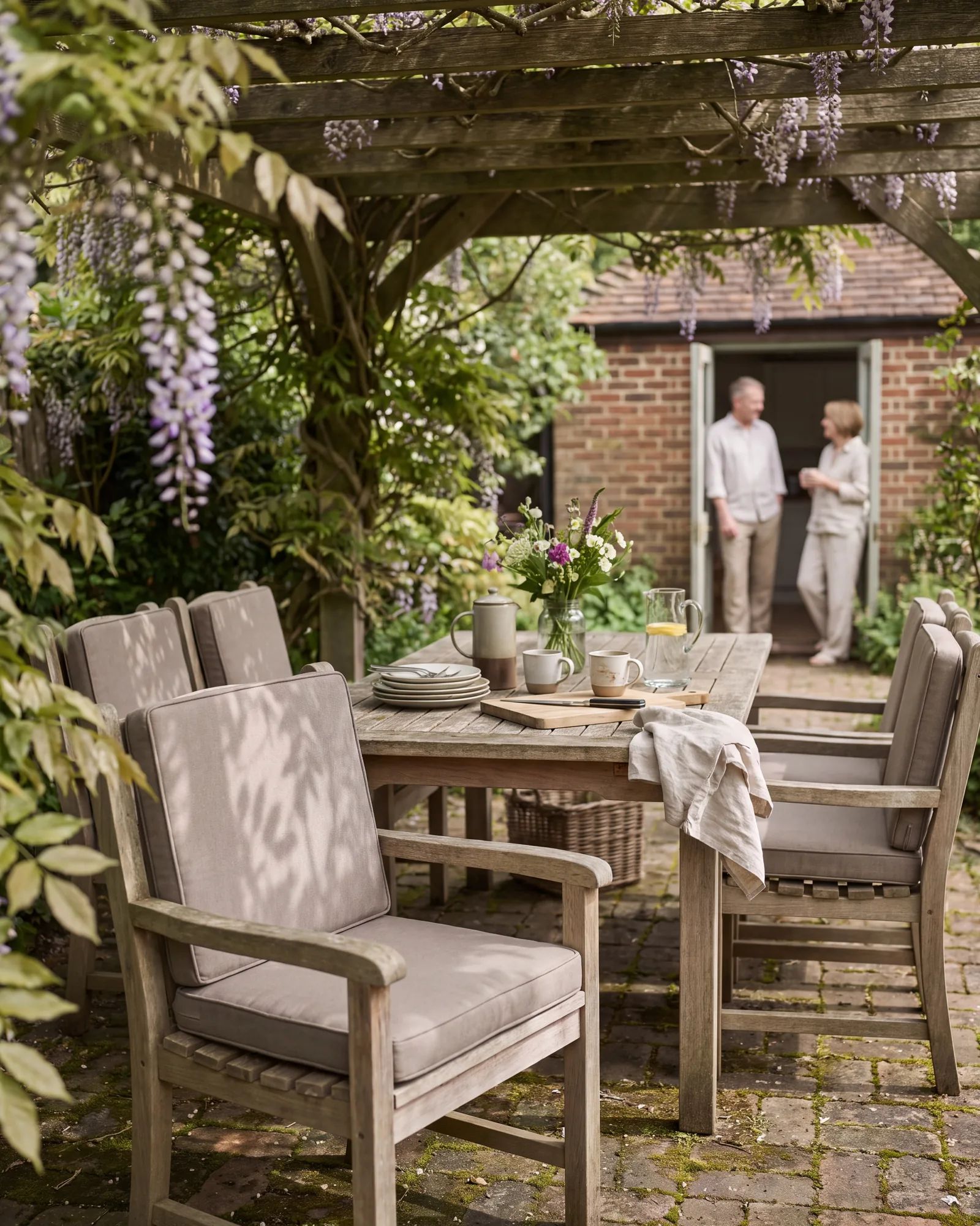 Tuinstoelen met bijpassende zitkussens op maat rond een houten tuintafel